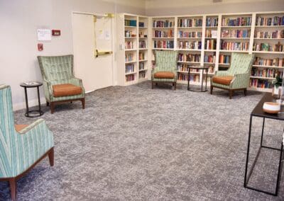 Library room with cozy reading chairs and full wall of bookshelves at Charter Senior Living of Paris, TN