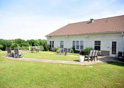 Outdoor seating area and walking paths at Charter Senior Living of Paris, surrounded by green lawns and scenic views.